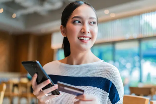 Woman holding a phone and credit card